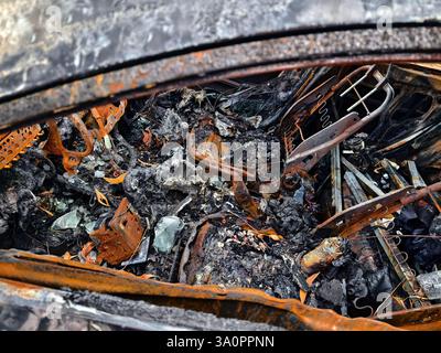Resti carbonizzati di un veicolo lasciato indietro dopo un devastante incidente d'incendio. Foto Stock