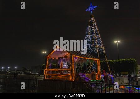 Un presepe splendidamente illuminato e un albero di Natale di notte di fronte alla Basilica di Guadalupe, che celebra le festività natalizie. Foto Stock