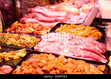 Diversi tipi di carne e verdura marinate in mostra al supermercato Foto Stock