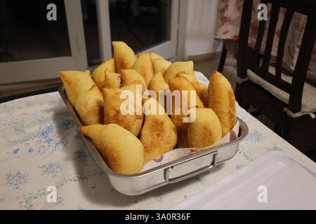 Vassoio pieno di panzerotti pronti, tradizionale piatto salato fritto pugliese. Ripieno di mozzarella e salsa di pomodoro Foto Stock