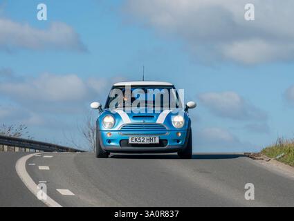 2002 R53 Mini Cooper S, piccolo portello caldo, che gira dietro un angolo acuto su una veloce strada di campagna nel Kent, nel sud-est dell'Inghilterra Foto Stock