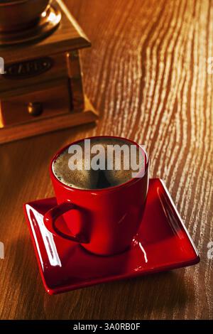 Tazza di cappuchino e macinacaffè su tavola di legno Foto Stock