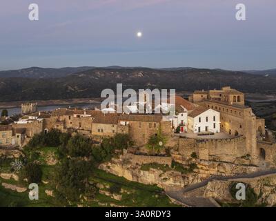 Il Villaggio bianco di Castillo de Castellar si trova all'interno di un castello moresco. Sopra il serbatoio Guadarranque. Con la luna piena all'alba. Antenna V Foto Stock