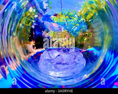 Un'affascinante fotografia artistica con una sfera di vetro che cattura i riflessi distorti di un ambiente esterno lussureggiante. Foto Stock