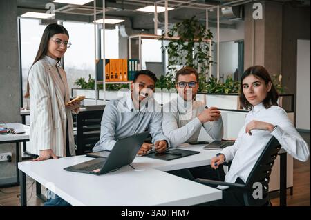 Quattro persone lavorano in ufficio insieme. Foto Stock