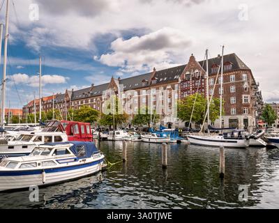 Barche a vela ormeggiate nel canale di Christianshavn con case storiche sul canale sullo sfondo, Copenaghen, Danimarca Foto Stock