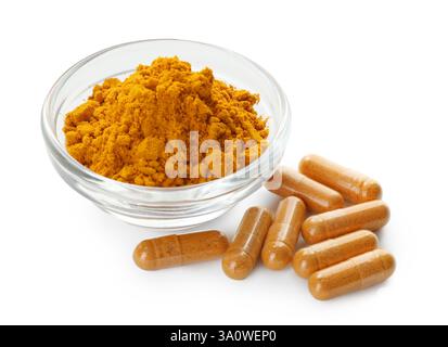 Polvere di curcuma in ciotola e capsule isolate su bianco Foto Stock