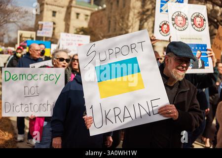 INDIANAPOLIS, INDIANA - 4 MARZO: Un manifestante tiene un cartello con la scritta "Support Ukraine", durante una manifestazione contro il presidente Donald Trump e Elon Musk, e l'amministrazione Trump il 4 marzo 2025 fuori dallo statehouse di Indianapolis, Indiana. La manifestazione del 4 marzo per la democrazia faceva parte di un appello nazionale all'azione del movimento del 50501, che rappresenta 50 proteste, 50 stati, un giorno. Foto Stock