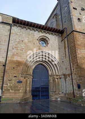 Ingresso gotico in pietra della chiesa di San Juan Bautista a LaGuardia, Spagna, caratterizzato da un arco ornato e sculture medievali. Foto Stock