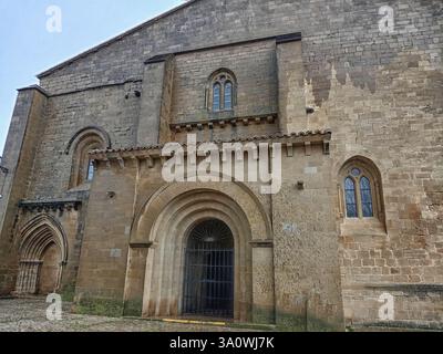 La facciata medievale della chiesa di San Juan Bautista a LaGuardia, Spagna, presenta elementi romanici e gotici con ingressi ad arco. Foto Stock
