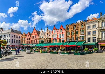 Edifici tradizionali fiamminghi in stile barocco con facciate colorate e ristoranti sulla piazza del mercato nella città vecchia di Bruges Foto Stock