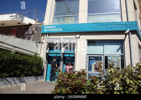 Uomo e donna che usano la cassa della banca nazionale greca Glyfada Atene Attica Grecia Foto Stock