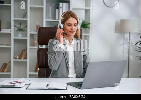 La donna in abiti da lavoro sta lavorando in ufficio. Foto Stock