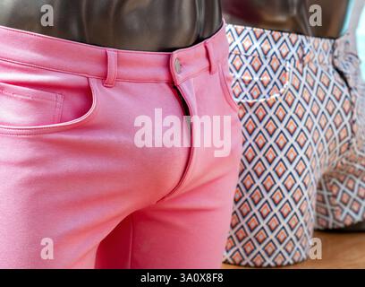 Due manichini espongono gli shorts alla moda da uomo: Uno rosa e l'altro con un motivo geometrico, presentati come un'espressione di stile in un ambiente di vendita al dettaglio. Foto Stock