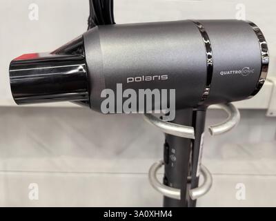 Bobruisk, Bielorussia - 22 febbraio 2025: Un asciugacapelli compatto con finitura nero-argento, che mette in risalto la tecnologia e il design moderni. Foto Stock