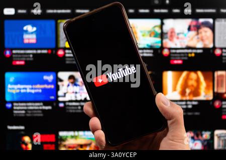 BOGOTÀ, COLOMBIA - 05 MARZO 2025 uno smartphone con logo youtube e interfaccia youtube sfocata sullo sfondo Foto Stock