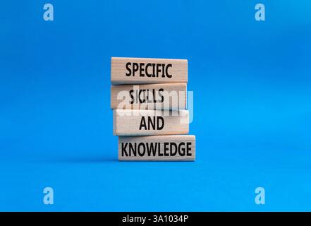 Simbolo di competenze e conoscenze specifiche. Blocchi di legno con parole competenze e conoscenze specifiche. Bellissimo sfondo blu. Competenze aziendali e specifiche Foto Stock