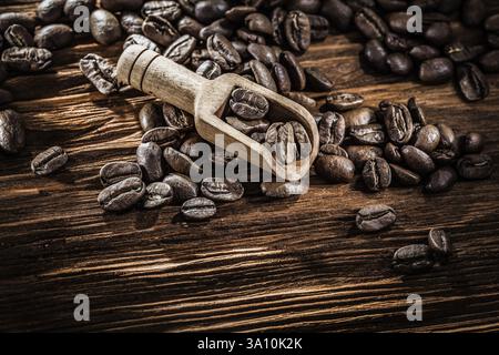 Grani di caffè in paletta su tavola di legno vintage Foto Stock