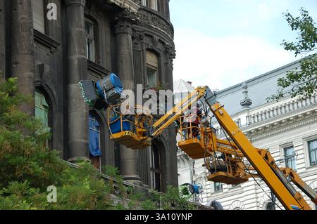La troupe cinematografica ha allestito l'illuminazione su piattaforme sopraelevate per Die Hard 5 (A Good Day to Die Hard) a Budapest, Ungheria. Edificio storico sullo sfondo Foto Stock