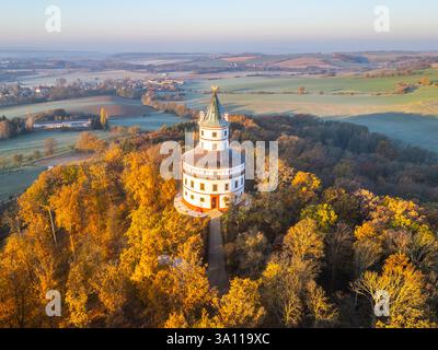 Il castello barocco di Humprecht, arroccato sopra Sobotka, brilla all'alba, circondato da un vivace fogliame autunnale e da paesaggi ondulati tipici della regione del Paradiso boemo. Foto Stock