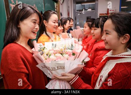 Wuhan, la provincia cinese di Hubei. 6 marzo 2025. Gli studenti presentano fiori ai loro insegnanti in una scuola elementare a Wuhan, nella provincia cinese di Hubei, il 6 marzo 2025. In tutto il paese si svolgono varie attività in occasione della giornata internazionale della donna. Crediti: Zhao Jun/Xinhua/Alamy Live News Foto Stock