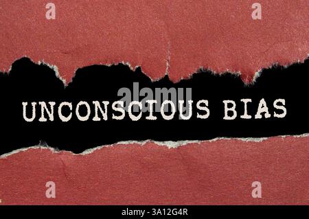 Messaggio di bias inconscio scritto su carta strappata rossa su sfondo nero. Simbolo di pregiudizio inconscio concettuale. Copia spazio. Foto Stock