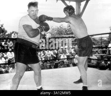 Conn spara A sinistra -- Billy Conn (a destra) rimbalza a sinistra dalla Jaw of sparring Mate Mickey McAvoy durante la sessione di allenamento al suo campo di ieri, mentre si prepara per il suo incontro per il titolo dei pesi massimi di 15 round a New York City il 19 giugno contro Joe Louis. 13 giugno 1946. (Foto di AP Wirephoto). Foto Stock