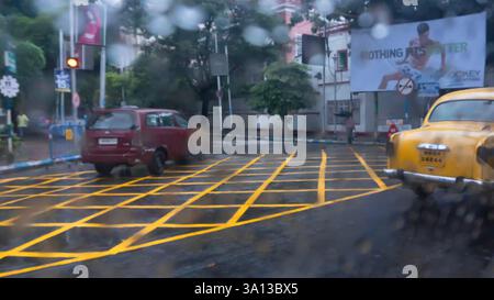 Kolkata, Bengala Occidentale, India - 25 settembre 2019 : immagine scattata attraverso gocce di pioggia cadute su vetro umido, sfocature astratte di zebre attraversate - monsone. Foto Stock