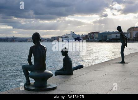 Scultura in bronzo sul lungomare Los Raqueros con il traghetto ibrido Brittany Ferries Guiilaume de Normandie nel porto di Santander Cantabria Spagna Europa Foto Stock