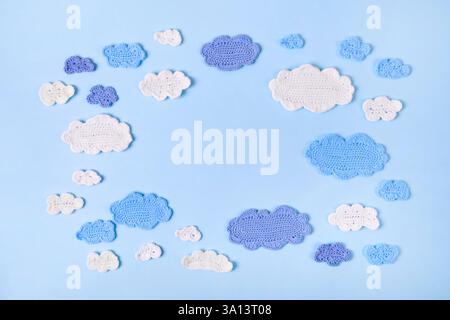 Nuvole blu e bianche su sfondo blu. Oggetti e accessori per bambini. Sfondo estivo astratto lavorato a maglia. Vista dall'alto, disposizione piatta, spazio di copia Foto Stock