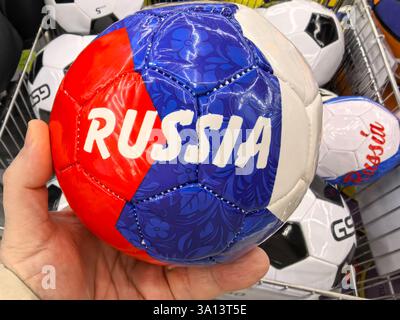 Bobruisk, Bielorussia - 22 febbraio 2025: La mano regge una pallina brillante con i colori della Russia. Il design della palla combina il disegno tradizionale Foto Stock