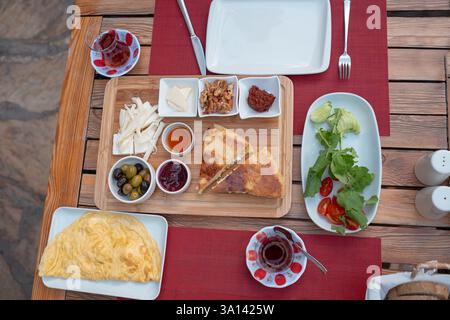Colazione tradizionale turca con pane fresco, olive, formaggio, pomodori, cetrioli, e varietà di inceppamenti e spalmazioni. Godibile in un ambiente vivace Foto Stock
