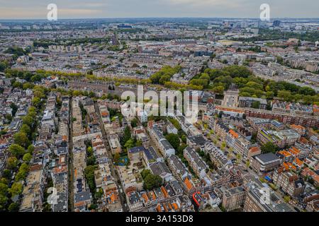 La vista aerea di Amsterdam, Paesi Bassi, mostra le sue iconiche case sui canali, l'architettura olandese e i tour in barca lungo il lungomare, catturando il fascino Foto Stock