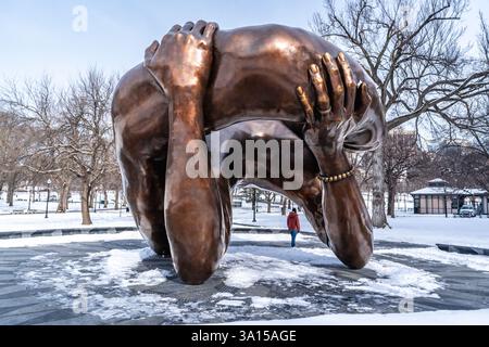 Boston, ma, USA - 11 febbraio 2025 - Una donna in piedi per scattare la sua foto vicino all'abbraccio, una scultura in bronzo di Hank Willis Thomas, installata su Bos Foto Stock