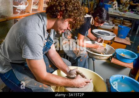 Due ceramisti che modellano l'argilla su ruote di ceramica in un laboratorio di ceramica Foto Stock