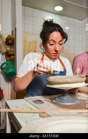 vasaio femminile che prepara l'argilla su una ruota di ceramica in officina Foto Stock