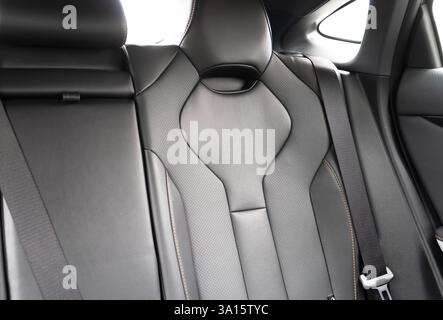 Sedili posteriori lato passeggero neri in una moderna auto di lusso. Pelle traforata nera con cuciture bianche. Dettagli dell'auto. Sedili confortevoli in pelle. D. Interno auto Foto Stock