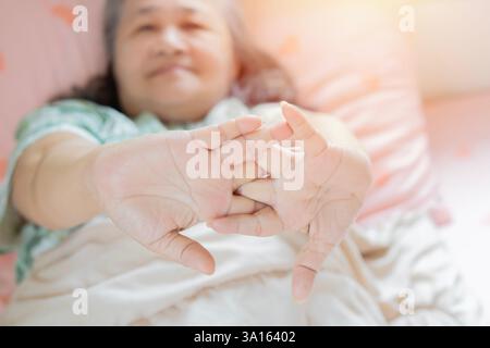 Felice fresca vecchia vecchia vecchia donna asiatica che si allunga nel letto svegliandosi da sola concetto felice. Messa a fuoco selettiva. Foto Stock