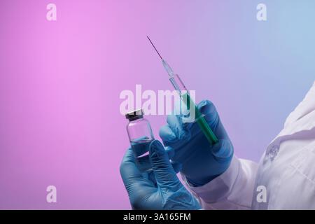 Medico in guanti blu che tiene una siringa con vaccino e flaconcino medicinale, preparazione per l'iniezione. Ricerca medica, immunizzazione, concetto di medicina moderna Foto Stock