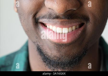 Uomo sorridente che mostra denti perfetti e gengive sane in un ritratto ravvicinato Foto Stock