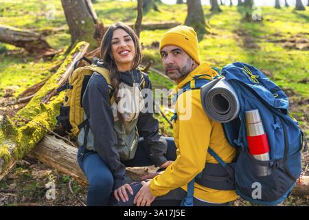 Gli escursionisti fanno una pausa nel bosco durante un'escursione di trekking, godendo della pace della natura Foto Stock