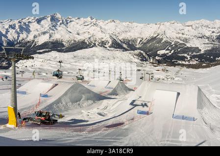 Stazione sciistica con impianti di risalita e lavoratori che preparano un parco freestyle. Shapers prepara il kicker nello snowpark. Madonna di Campiglio ursus neve Foto Stock