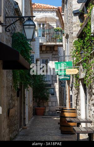 Budva, Montenegro - 23 agosto 2024: Vicolo stretto nella città vecchia con pub Foto Stock