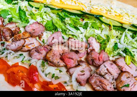 Un vivace taco propone carne alla griglia, strati di verdure fresche e formaggio fuso. Gli ingredienti colorati si uniscono in una tortilla, creando un Foto Stock