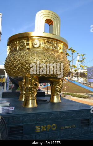 Padiglione China EXPO Milano 2015. Tradizionale bruciatore a incenso gigante cinese a tre zampe con treppiede dorato o ciotola del tesoro esposta all'aperto su piedistallo. Foto Stock