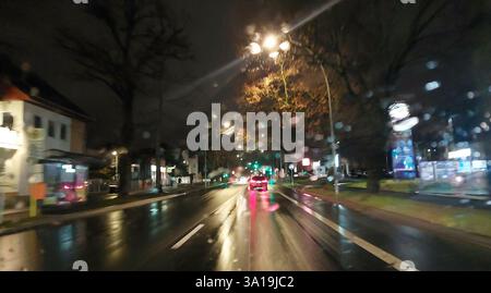 Vista del traffico cittadino attraverso il parabrezza sotto la pioggia e di notte Foto Stock