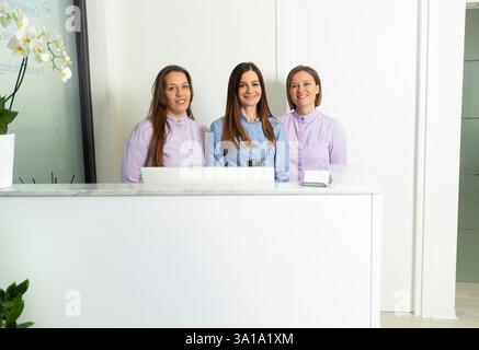 Personale sanitario in piedi alla reception, pronto ad assistere i pazienti in una moderna clinica odontoiatrica Foto Stock