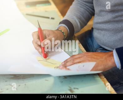 Calzolaio o scarpa designer che lavora con lcon libro modelli per taglio di pelle. Foto Stock