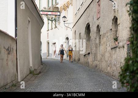 Due donne camminano lungo un vicolo acciottolato Salisburgo, Austria Foto Stock