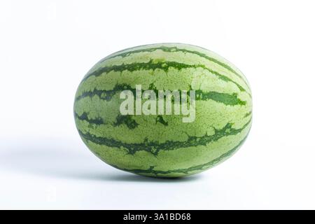 Un'anguria fresca si erge su uno sfondo bianco e pulito, mostrando la sua pelle e le sue strisce verdi vibranti, perfetta per una festa estiva o per una S naturale Foto Stock